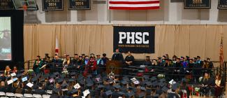 President Jesse Pisors on the podium with the class of graduates during graduation.